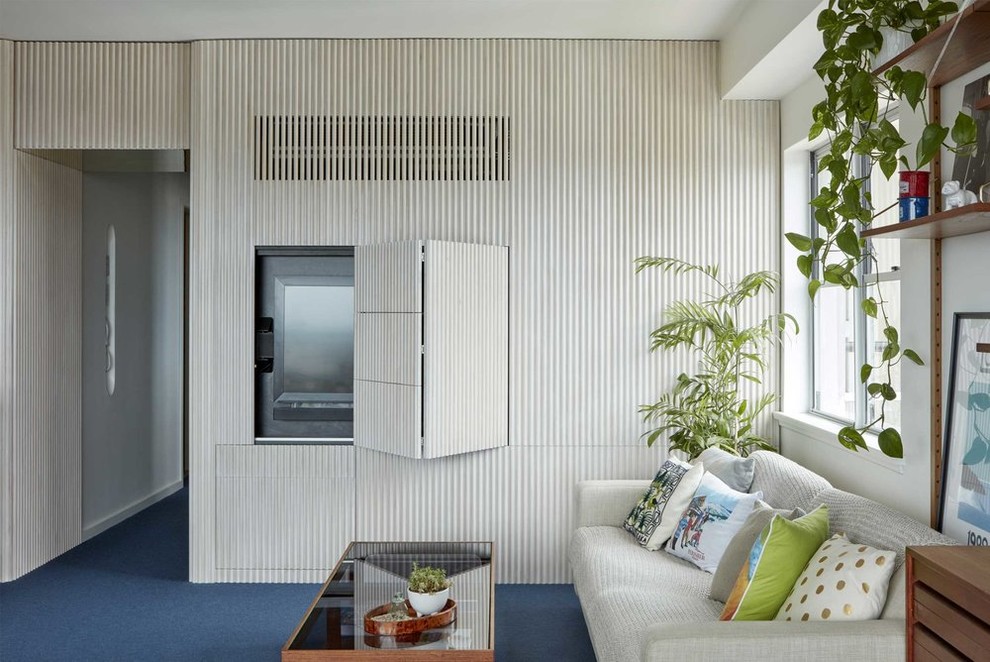 Пример оригинального дизайна: маленькая открытая гостиная комната в стиле ретро с ковровым покрытием, синим полом, белыми стенами и скрытым телевизором без камина для на участке и в саду