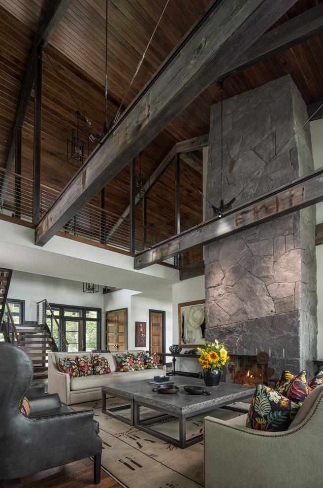Example of a large mountain style open concept dark wood floor and brown floor living room design in Other with white walls, a standard fireplace, a stone fireplace and no tv