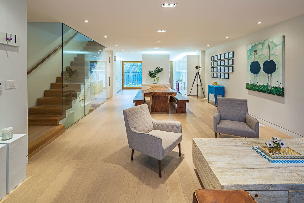 Diseño de salón para visitas abierto contemporáneo con suelo de madera en tonos medios y paredes blancas