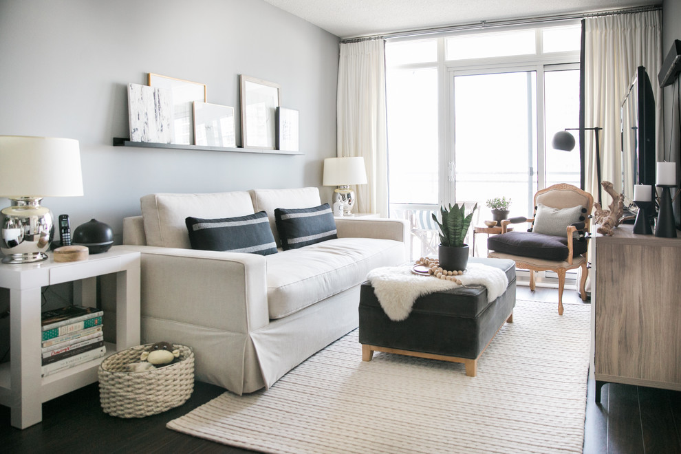 Foto di un piccolo soggiorno eclettico aperto con pareti grigie, parquet scuro e TV autoportante