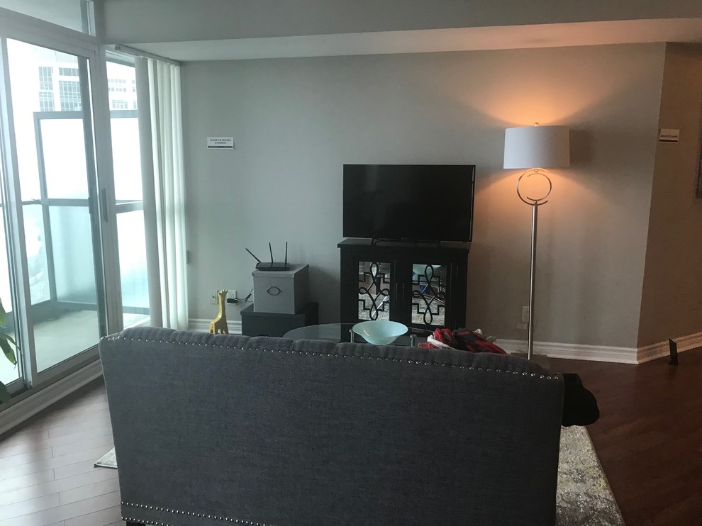 Mid-sized transitional open concept laminate floor and brown floor living room photo in Toronto with a bar, gray walls, a corner fireplace and a wall-mounted tv