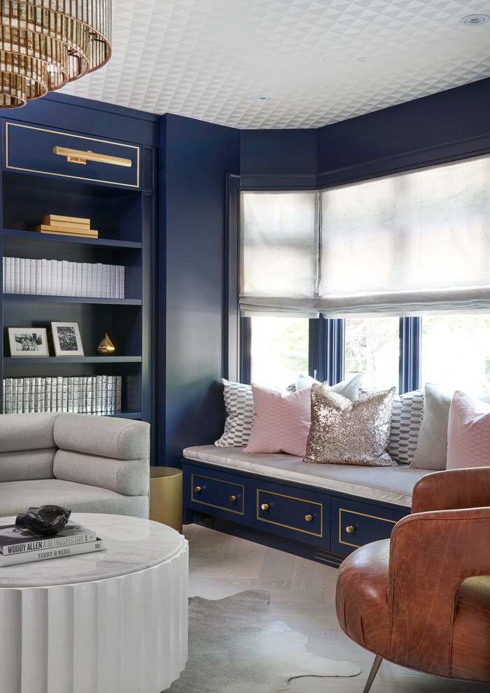 На фото: гостиная комната в современном стиле с с книжными шкафами и полками и синими стенами