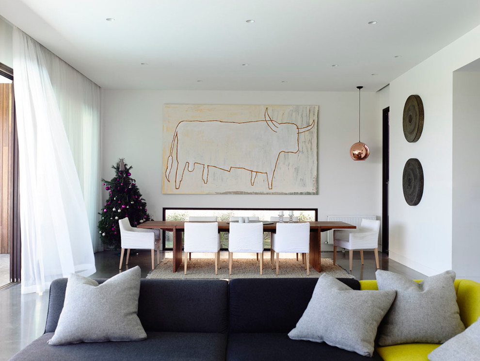 Immagine di un grande soggiorno design aperto con sala formale, pareti bianche, pavimento in cemento, stufa a legna, cornice del camino in legno e TV nascosta