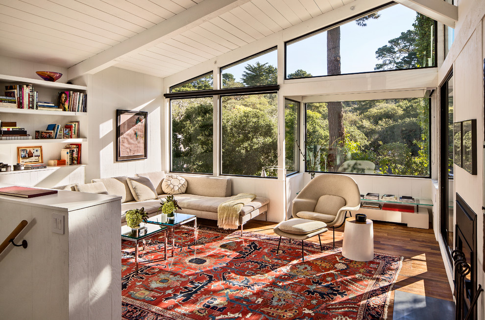 This is an example of a midcentury living room in San Francisco with white walls and medium hardwood flooring.