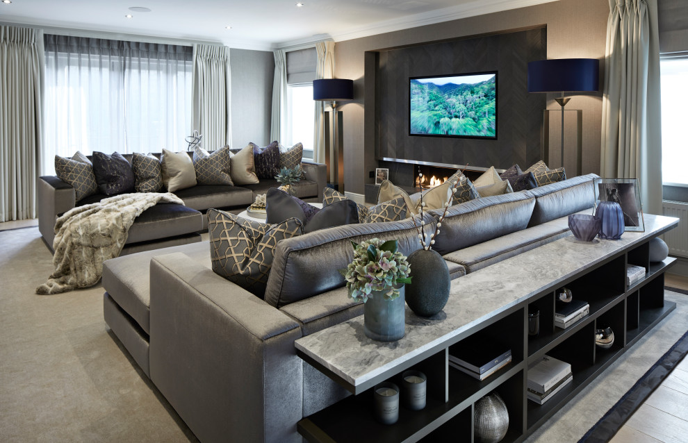 Großes, Abgetrenntes Modernes Wohnzimmer mit grauer Wandfarbe, Teppichboden, Hängekamin, Kaminumrandung aus Holz, TV-Wand und grauem Boden in Surrey