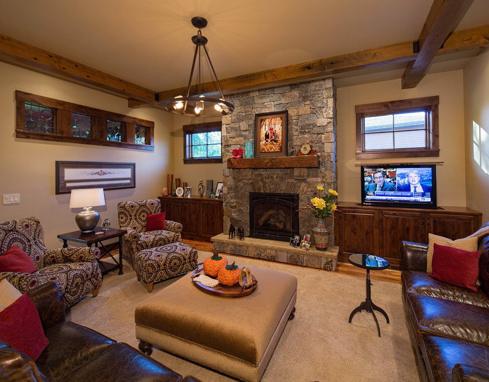 На фото: изолированная гостиная комната среднего размера в классическом стиле с коричневыми стенами, темным паркетным полом, стандартным камином, фасадом камина из камня и отдельно стоящим телевизором