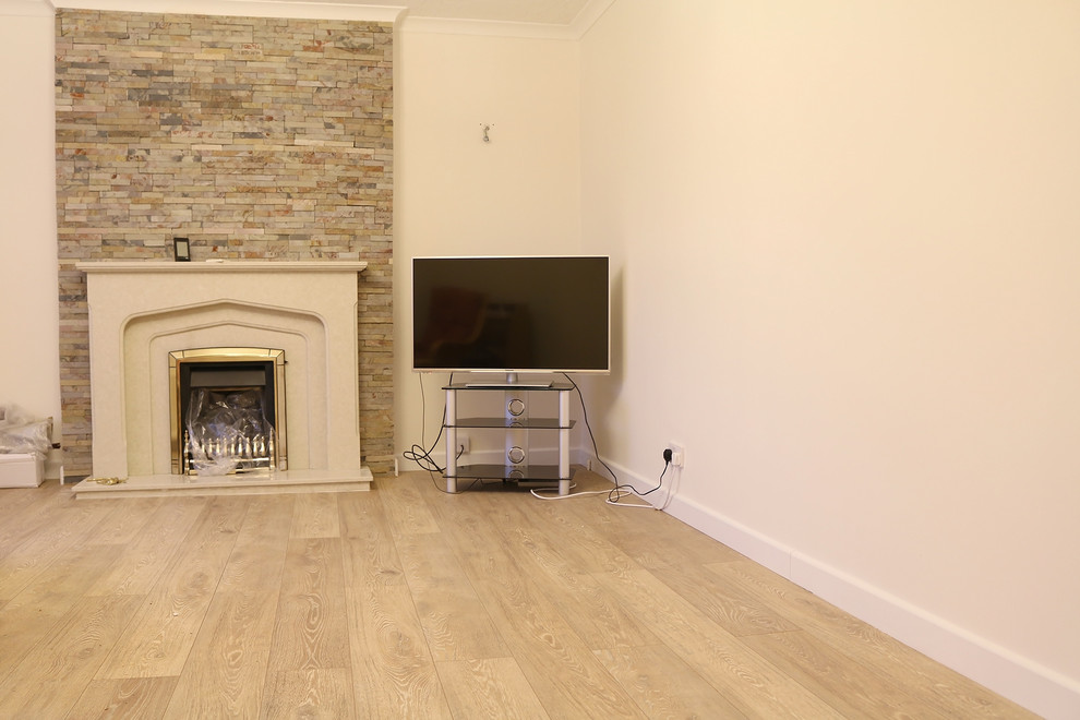 Modern inredning av ett separat vardagsrum, med ett finrum, beige väggar, laminatgolv, en standard öppen spis, en spiselkrans i trä, en fristående TV och beiget golv