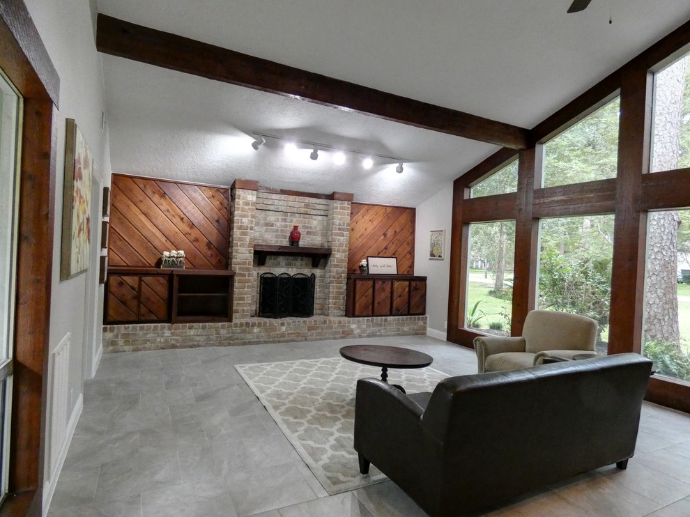 Large contemporary mezzanine living room in Houston with grey walls, ceramic flooring, a standard fireplace, a brick fireplace surround, no tv and grey floors.
