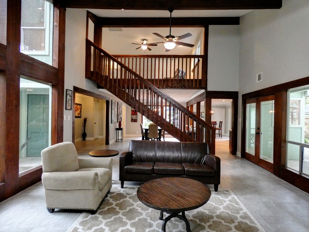 Inspiration for a large traditional mezzanine living room in Houston with grey walls, ceramic flooring, a standard fireplace, a brick fireplace surround, no tv and grey floors.