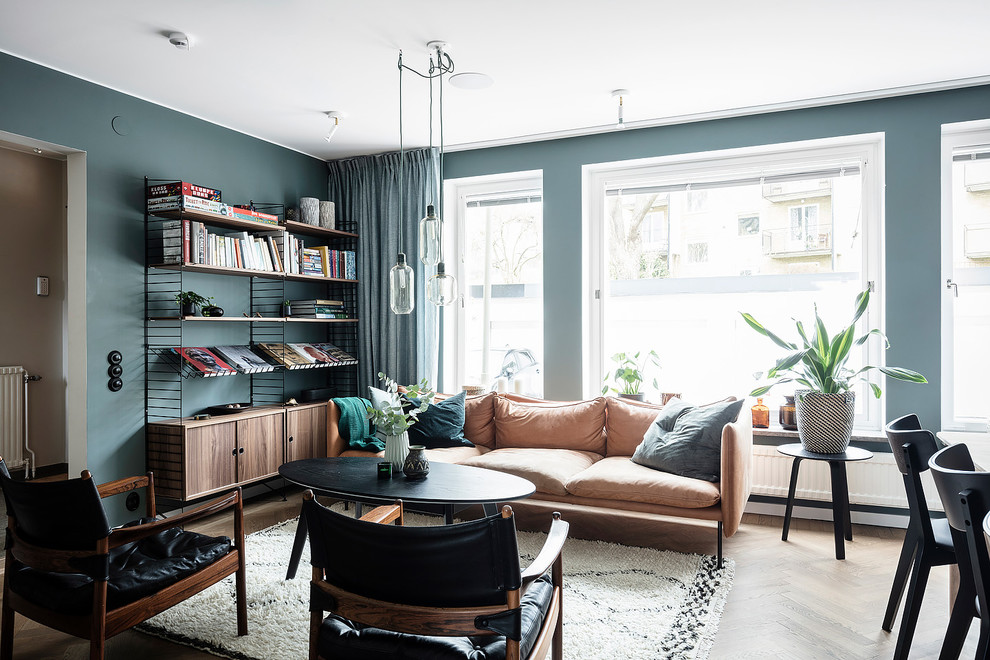 Bild på ett stort minimalistiskt allrum med öppen planlösning, med blå väggar, mörkt trägolv, en standard öppen spis, en spiselkrans i gips, en väggmonterad TV och brunt golv