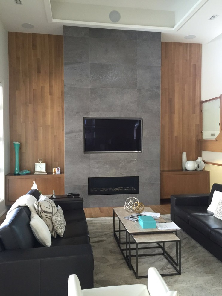 Large minimalist open concept light wood floor living room photo in Toronto with a stone fireplace and a media wall