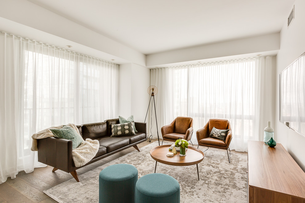 Esempio di un soggiorno minimal di medie dimensioni e aperto con pareti bianche, pavimento in legno massello medio e TV a parete
