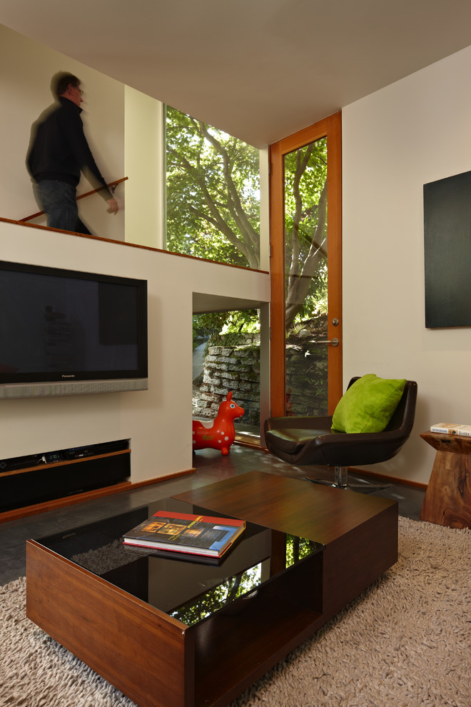 Photo of a modern living room in Seattle with beige walls and a wall mounted tv.