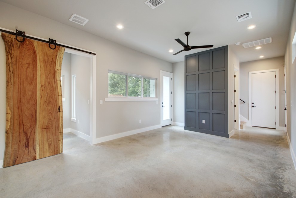 Mittelgroßes, Offenes Modernes Wohnzimmer mit Betonboden, buntem Boden und grauer Wandfarbe in Austin
