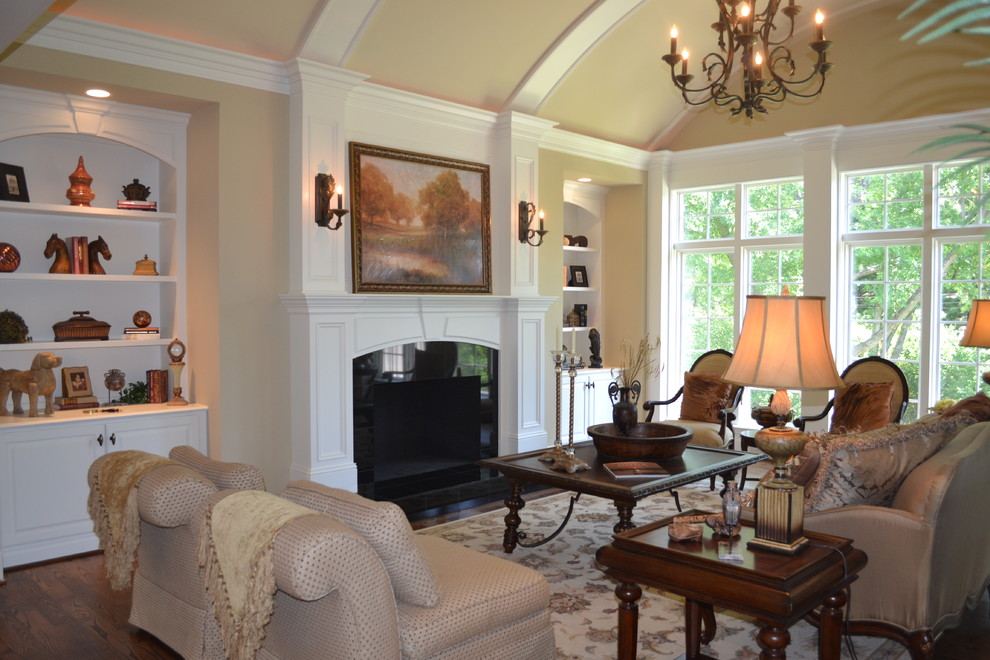 Inspiration for a medium sized classic formal enclosed living room in St Louis with beige walls, dark hardwood flooring, a standard fireplace, a wooden fireplace surround and no tv.