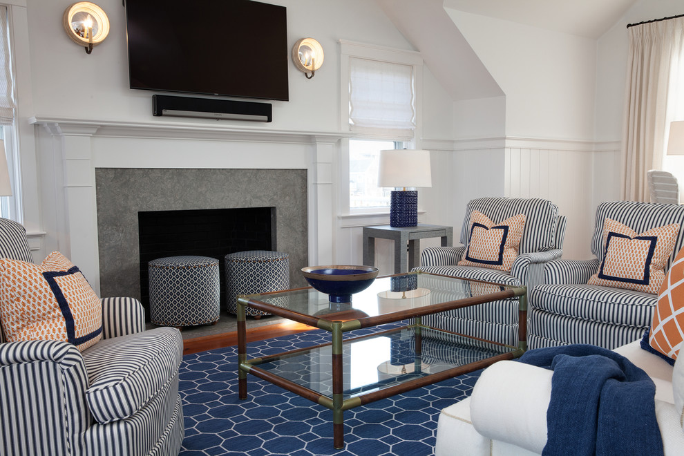 Maritimes Wohnzimmer mit weißer Wandfarbe, braunem Holzboden, Kamin, Kaminumrandung aus Stein und TV-Wand in Boston