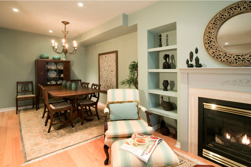 Cette photo montre un salon chic de taille moyenne et ouvert avec une salle de réception, parquet clair, une cheminée standard, un mur bleu, un manteau de cheminée en plâtre et un sol marron.