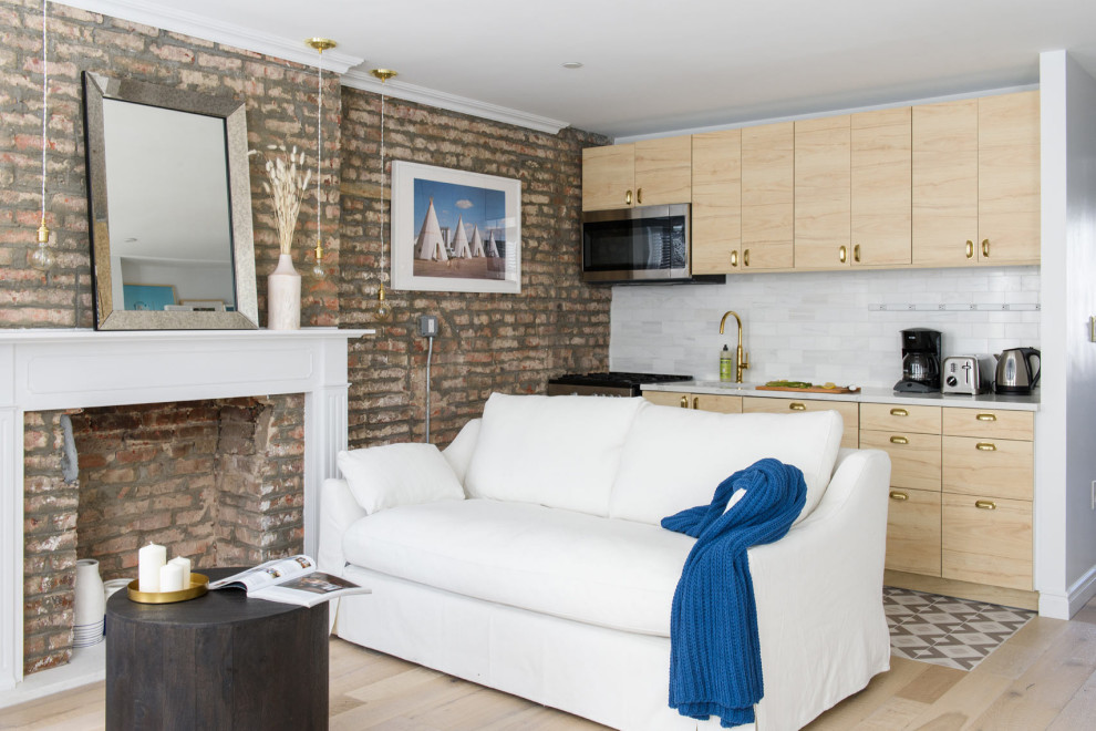 На фото: открытая гостиная комната в стиле неоклассика (современная классика) с белыми стенами, светлым паркетным полом, стандартным камином, бежевым полом и кирпичными стенами