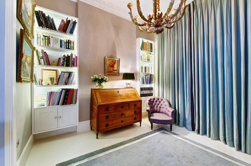 This is an example of a medium sized traditional open plan living room in London with a reading nook, grey walls, no fireplace, no tv and painted wood flooring.