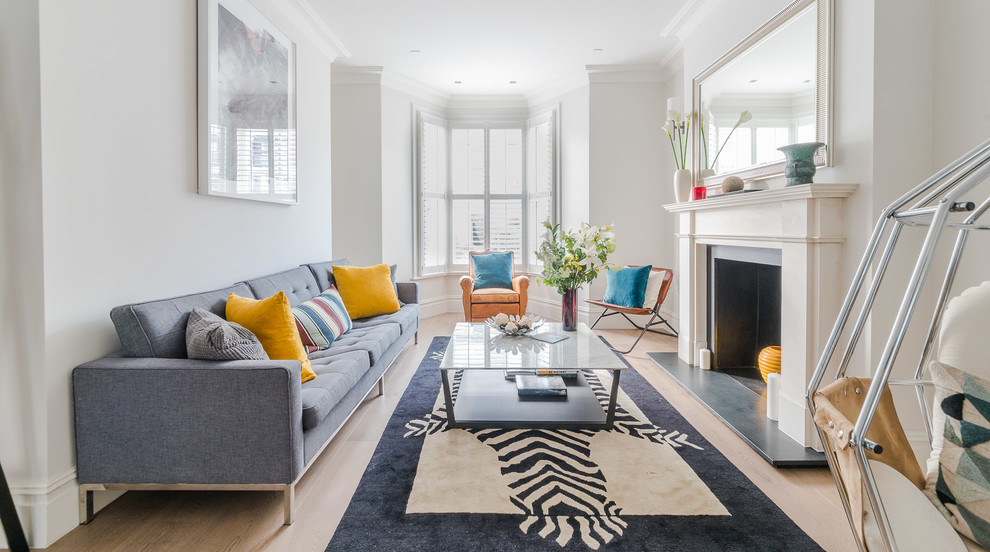 Foto di un soggiorno classico di medie dimensioni con parquet chiaro, pavimento beige, pareti bianche e camino classico