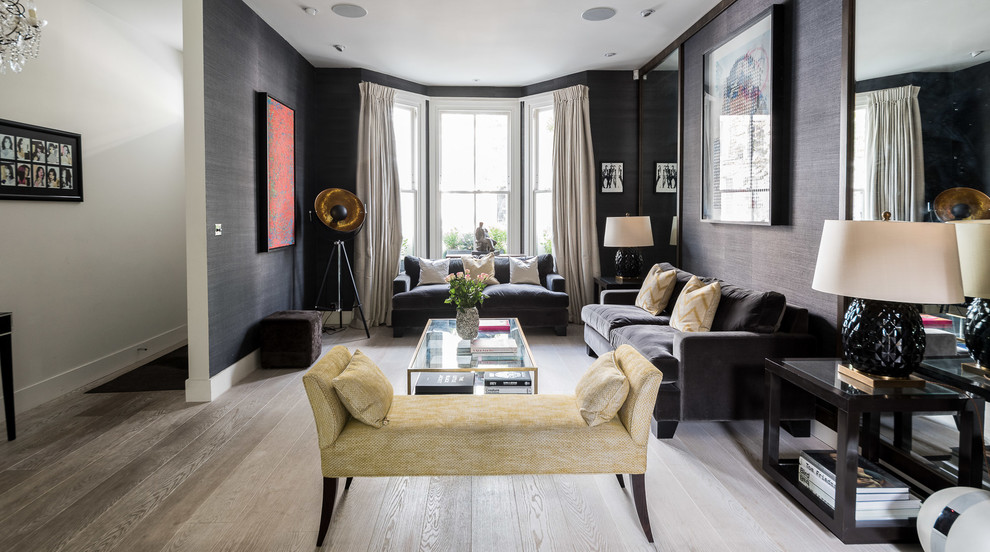 Example of a transitional enclosed light wood floor and gray floor living room design in London with black walls