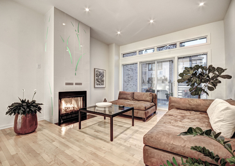 Идея дизайна: гостиная комната в современном стиле с белыми стенами, стандартным камином, бежевым полом и коричневым диваном
