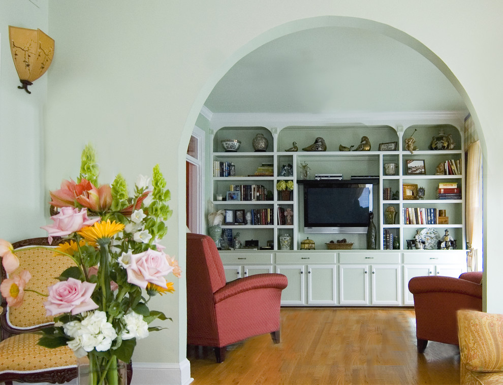 Inredning av ett klassiskt separat vardagsrum, med ett bibliotek och en väggmonterad TV
