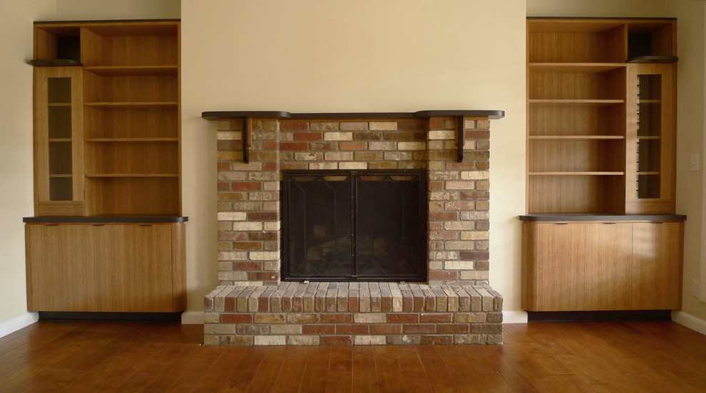 Foto de salón abierto minimalista de tamaño medio con paredes beige, suelo de madera en tonos medios, todas las chimeneas y marco de chimenea de ladrillo