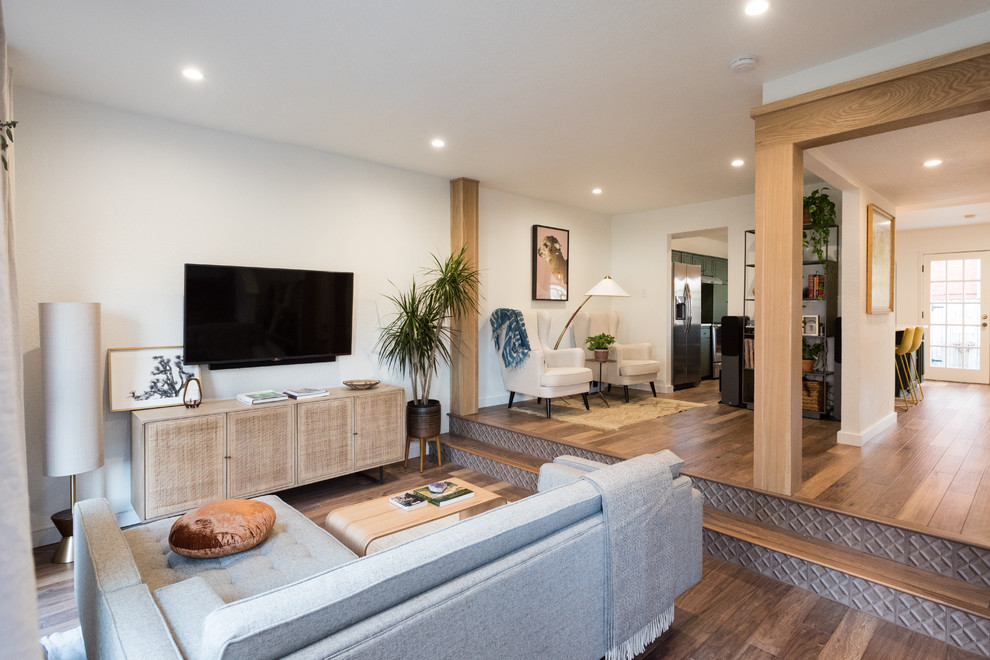 Foto di un piccolo soggiorno tradizionale aperto con pareti bianche, pavimento in legno massello medio, TV a parete e pavimento marrone