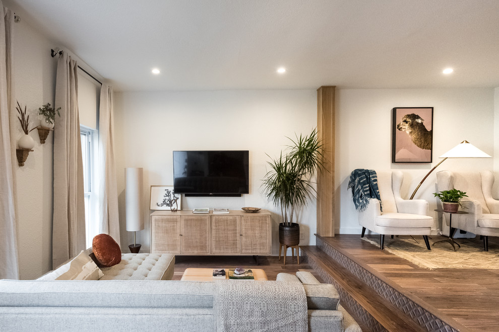 Foto de salón abierto moderno pequeño con paredes blancas, suelo de madera en tonos medios y televisor colgado en la pared