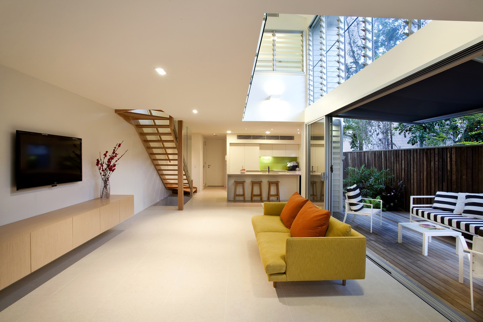 Foto di un grande soggiorno tropicale aperto con pareti bianche, TV a parete e pavimento in travertino