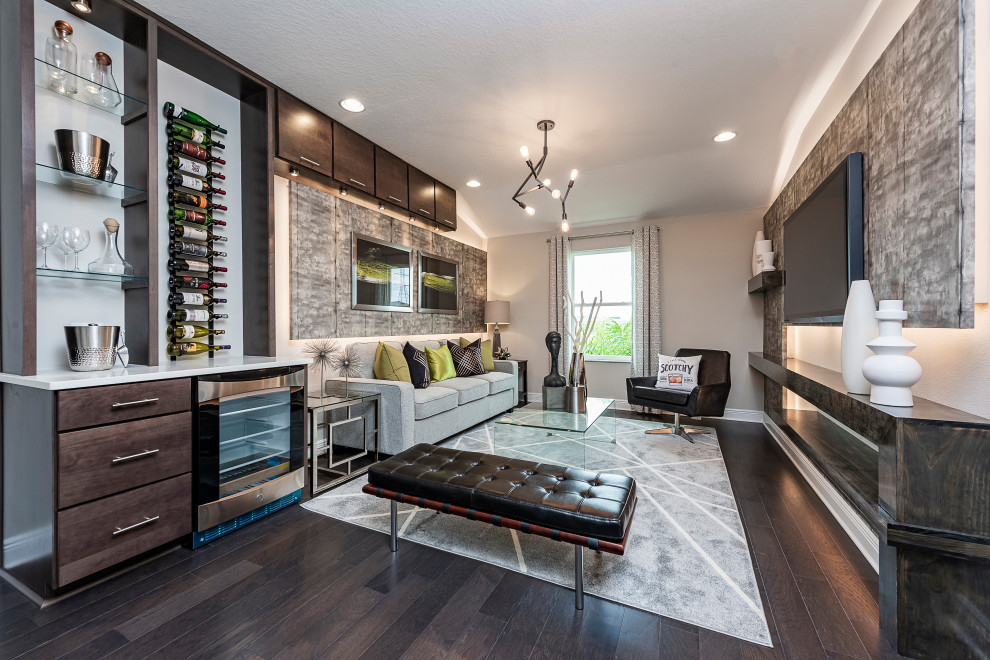 Foto di un soggiorno minimalista stile loft con angolo bar, pareti grigie, parquet scuro e TV a parete