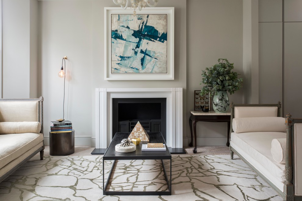 This is an example of a traditional formal living room in London with grey walls and a standard fireplace.