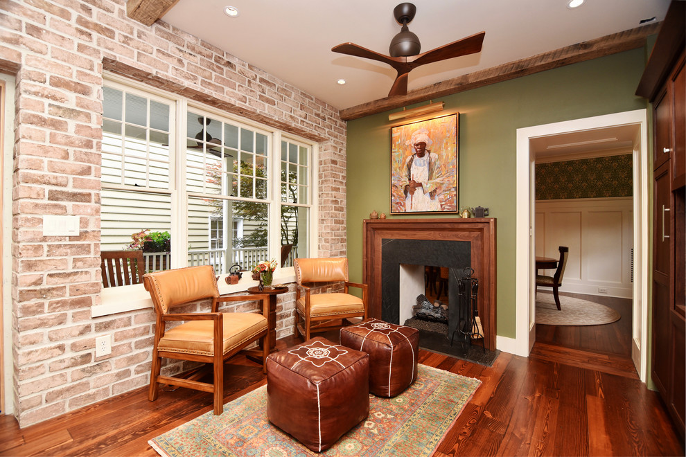 Cette image montre un petit salon traditionnel avec un mur vert, un sol en bois brun, une cheminée double-face, un manteau de cheminée en bois, un téléviseur encastré et un sol marron.