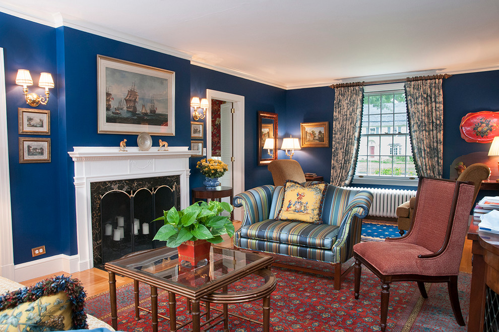 Immagine di un soggiorno tradizionale con pareti blu, pavimento in legno massello medio, camino classico, sala formale e nessuna TV
