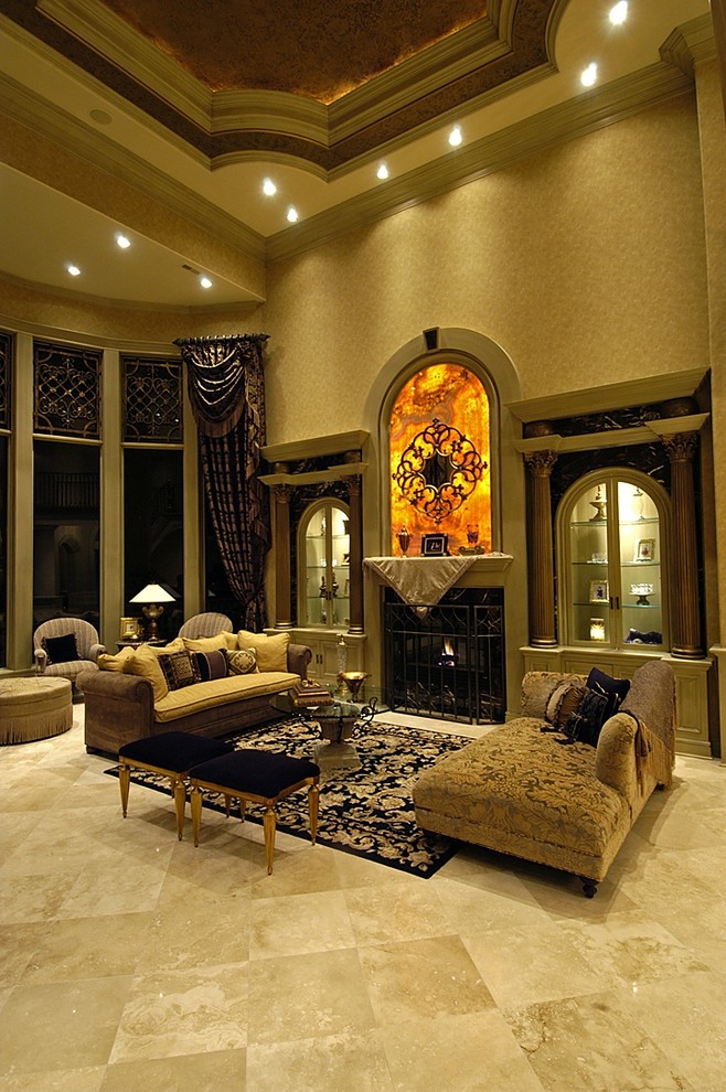 На фото: огромная парадная, открытая гостиная комната в классическом стиле с бежевыми стенами, полом из травертина, стандартным камином и фасадом камина из камня