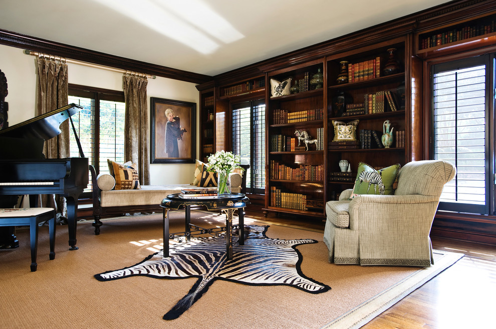 Imagen de biblioteca en casa cerrada bohemia con paredes beige, suelo de madera en tonos medios y suelo marrón