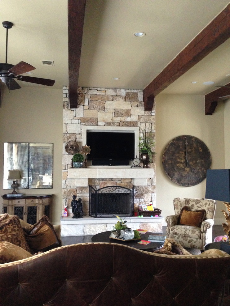 Photo of a medium sized classic open plan living room in Austin with beige walls, medium hardwood flooring, a standard fireplace, a stone fireplace surround and a wall mounted tv.