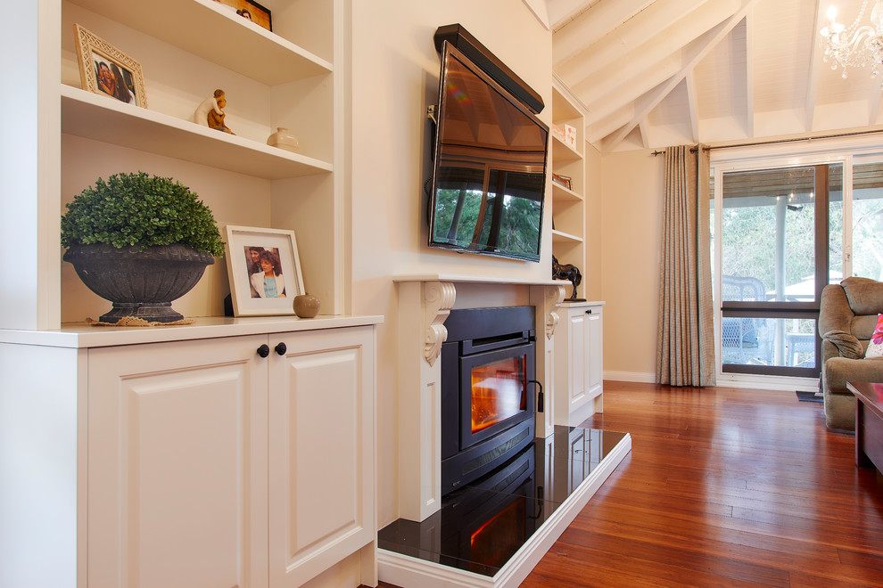 Exempel på ett stort klassiskt allrum med öppen planlösning, med ett finrum, vita väggar, mörkt trägolv, en standard öppen spis, en spiselkrans i trä, en väggmonterad TV och brunt golv