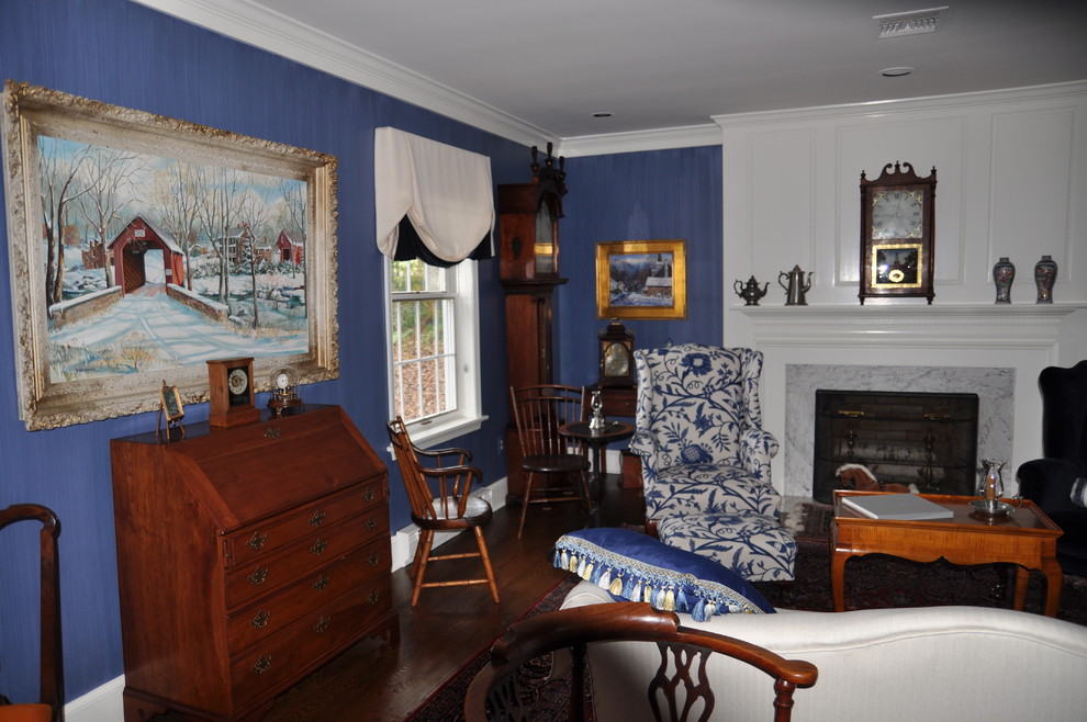 Стильный дизайн: маленькая парадная, изолированная гостиная комната в классическом стиле с синими стенами, темным паркетным полом, стандартным камином, фасадом камина из камня и коричневым полом без телевизора для на участке и в саду - последний тренд