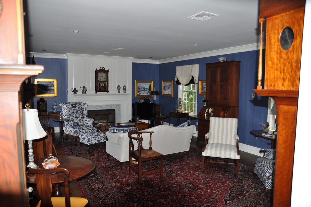 Bild på ett litet vintage separat vardagsrum, med ett finrum, blå väggar, mörkt trägolv, en standard öppen spis, en spiselkrans i sten och brunt golv