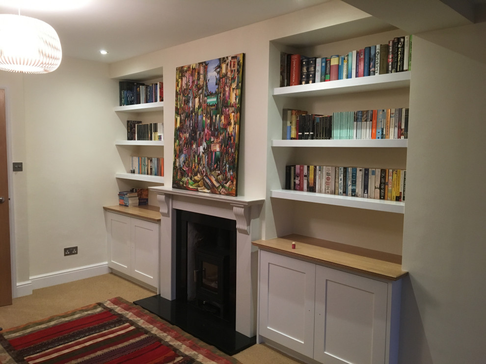 Mittelgroßes, Abgetrenntes Klassisches Wohnzimmer mit beiger Wandfarbe, Teppichboden, Kamin, Kaminumrandung aus Stein, freistehendem TV und beigem Boden in Buckinghamshire