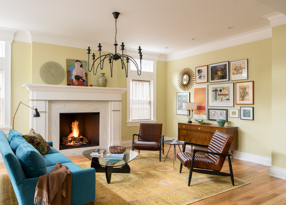 デンバーにあるトラディショナルスタイルのおしゃれなリビング (黄色い壁、無垢フローリング、標準型暖炉、石材の暖炉まわり、茶色い床) の写真