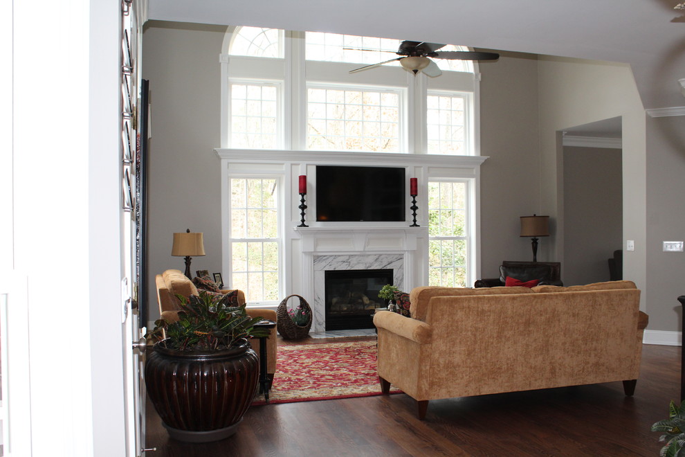 Mittelgroßes, Repräsentatives, Offenes Klassisches Wohnzimmer mit beiger Wandfarbe, dunklem Holzboden, Kamin, gefliester Kaminumrandung und TV-Wand in Raleigh