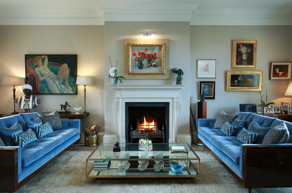 Photo of a classic formal living room in London with beige walls, a standard fireplace and a metal fireplace surround.