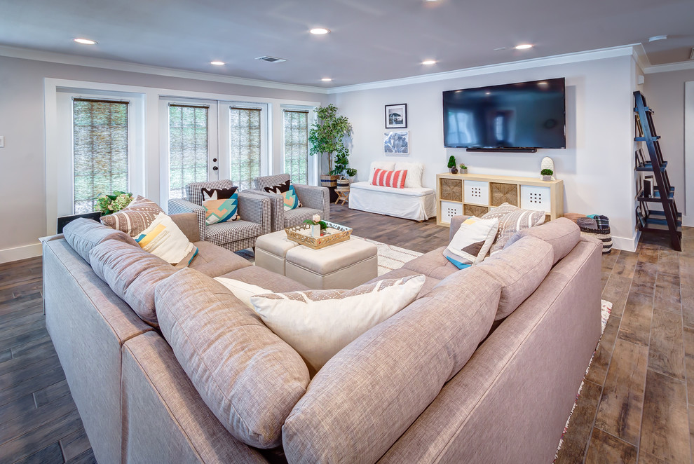 Foto di un soggiorno chic di medie dimensioni e aperto con pareti grigie, pavimento in gres porcellanato, TV a parete e pavimento marrone
