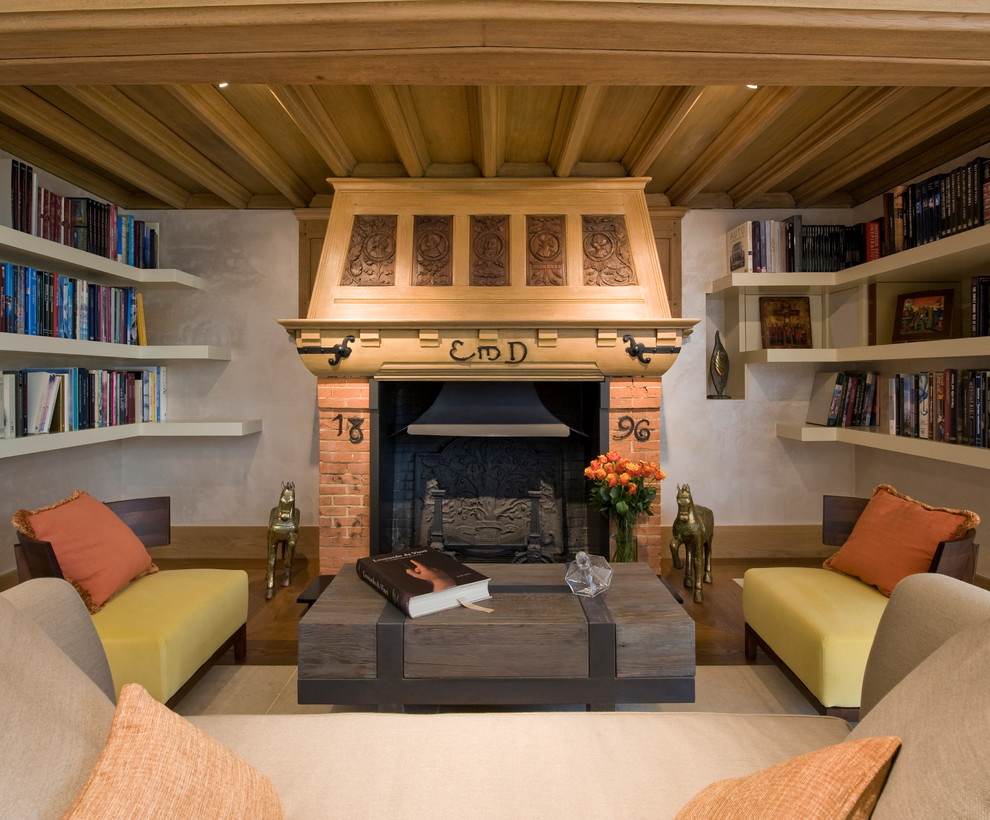 Imagen de biblioteca en casa de estilo de casa de campo pequeña con suelo de madera oscura, estufa de leña y marco de chimenea de ladrillo