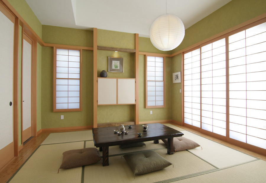 Large zen enclosed light wood floor living room photo in Los Angeles with green walls, a concealed tv and no fireplace