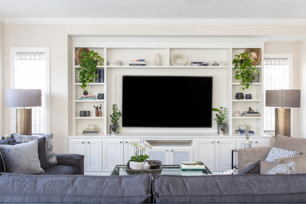 Inspiration pour un salon traditionnel avec un mur beige et un téléviseur encastré.