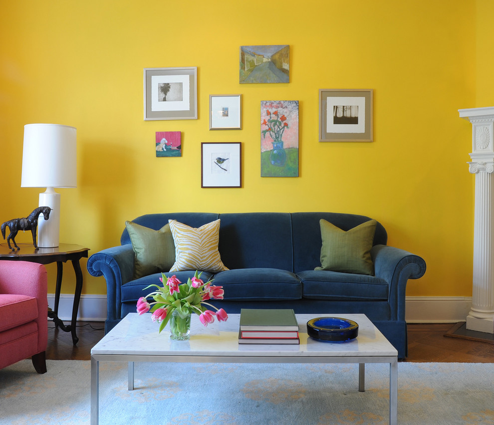 ワシントンD.C.にある中くらいなトラディショナルスタイルのおしゃれなリビング (黄色い壁、コーナー設置型暖炉、木材の暖炉まわり、無垢フローリング、テレビなし) の写真